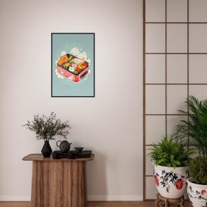May include: A framed illustration of a pink bento box filled with cartoon cats and food. The cats are in various poses and the food includes vegetables, rice, and fish. The background is a light blue with white clouds and pink cherry blossoms.