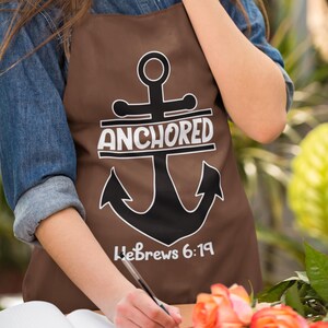 May include: Brown apron with a black anchor and the text "Anchored Hebrews 6:19".