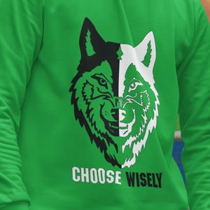May include: Green sweatshirt with a black and white wolf graphic and the text "CHOOSE WISELY" printed on the front.