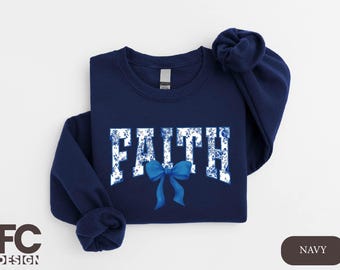 May include: Navy blue sweatshirt with a white "FAITH" graphic with a blue floral pattern and a blue bow.