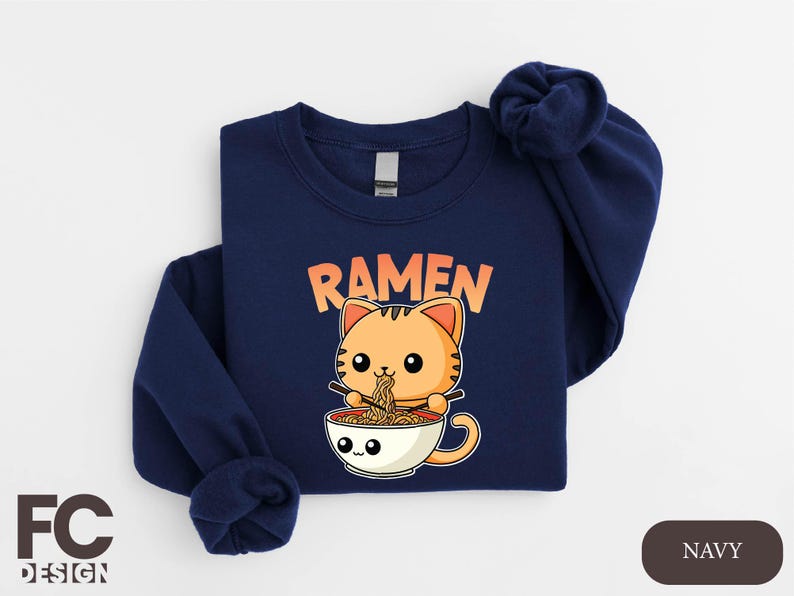 a blue shirt with a cat eating ramen out of a bowl