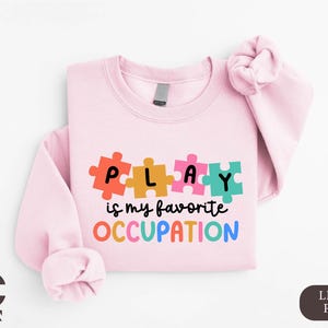 a pink shirt with puzzle pieces on it