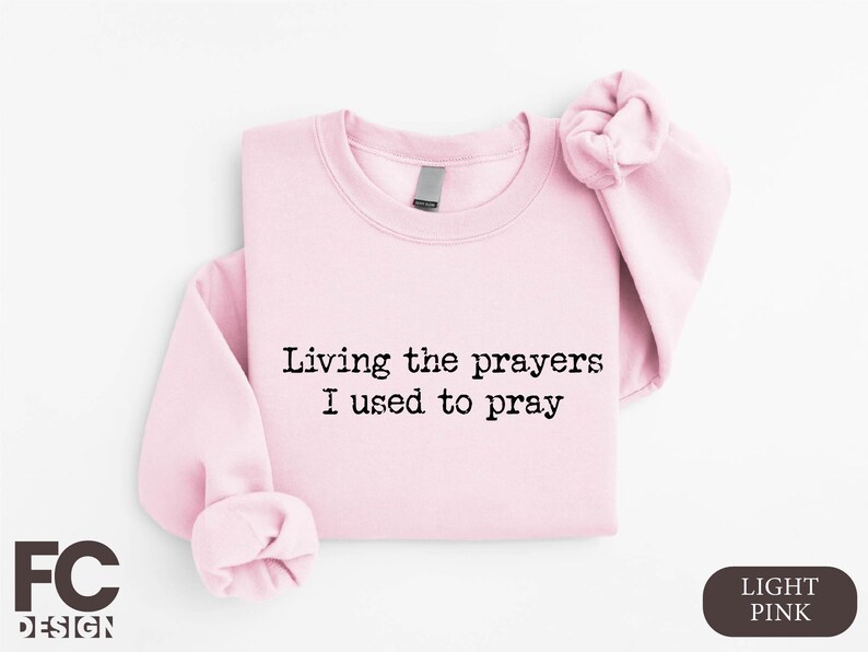 a pink shirt with a saying saying living the prayers i used to pray