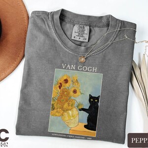 a t - shirt with a picture of a vase of sunflowers and a