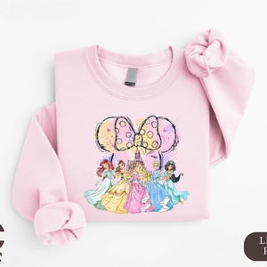 a pink shirt with a picture of princesses on it