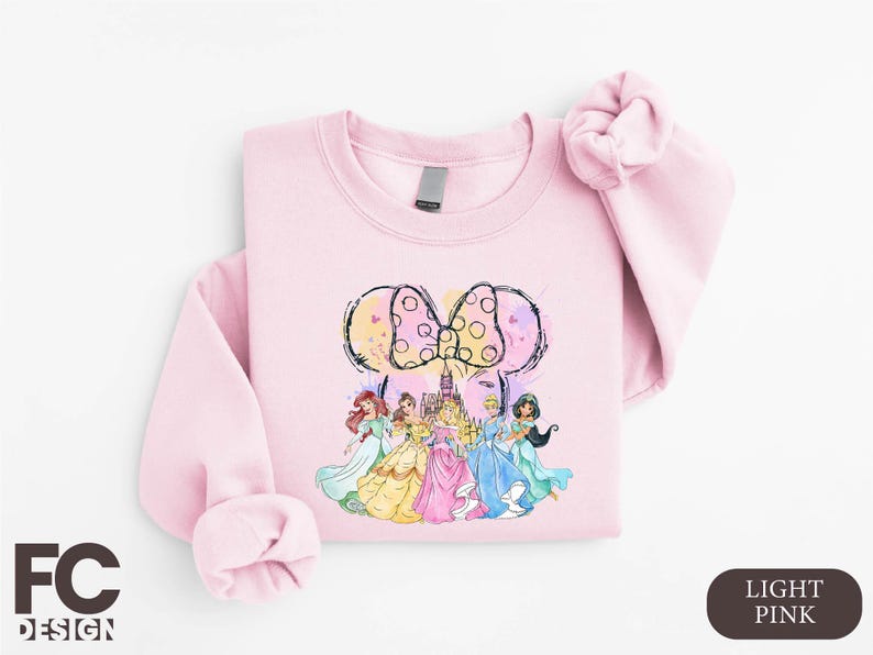 a pink shirt with a picture of princesses on it