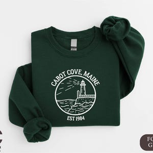 a green sweatshirt with a lighthouse on it