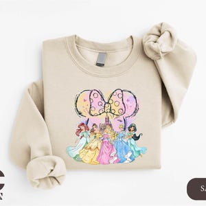 a sweatshirt with a picture of a group of princesses on it