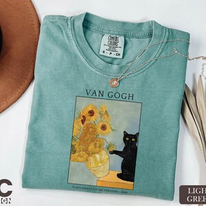 a t - shirt with a picture of a vase of sunflowers and a