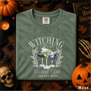 a green t-shirt with a Halloween-themed design, surrounded by Halloween decorations such as a skull, a pumpkin, and bats.