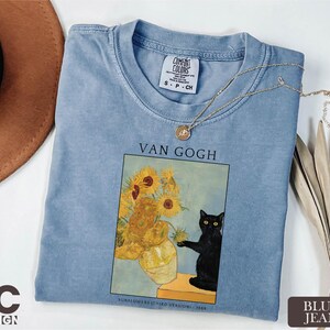 a t - shirt with a picture of a vase of sunflowers and a