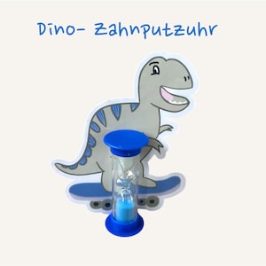 Könnte beinhalten: Ein Cartoon-Dinosaurier in Grau und Blau, der auf einem Skateboard fährt, mit einem blauen Stundenglas-Timer. Der Text "Dino-Zahnpfutzhr" steht in Blau über dem Dinosaurier. Das Stundenglas ist mit blauem Sand gefüllt.