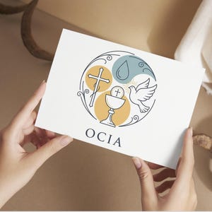 Puede incluir: Una tarjeta blanca con un dise&ntilde;o circular de s&iacute;mbolos religiosos: una cruz, un c&aacute;liz, una paloma y una gota de agua. El dise&ntilde;o utiliza amarillo, azul y blanco, con la palabra "OCIA" en la parte inferior. La tarjeta est&aacute; sostenida por manos.