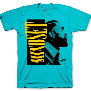 May include: A turquoise t-shirt featuring a graphic design. The design includes a black and yellow abstract shape with the word "Hustle" and a side profile of a man with a beard. The shirt has the word "Sneakers" in the bottom right corner.