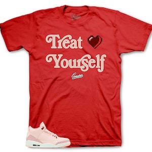 Puede incluir: Camiseta roja con el texto "Treat Yourself" en fuente rosa con un corazón pixelado en el medio. Un par de zapatillas rosas y blancas se encuentran en la esquina inferior izquierda de la imagen.