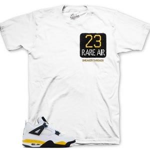 May include: A white short-sleeve t-shirt featuring a black square graphic on the chest with the yellow text 23 and white text RARE AIR, plus the words SNEAKER THREADS below. A white, black, and yellow sneaker is positioned at the bottom left.
