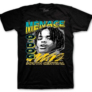 May include: Black t-shirt featuring a graphic of a person with the word "MENACE" in teal and yellow. The text "O-DOG" is vertically aligned on the left side, and "SOUTH CENTRAL" is at the bottom. The graphic is in a vintage style.