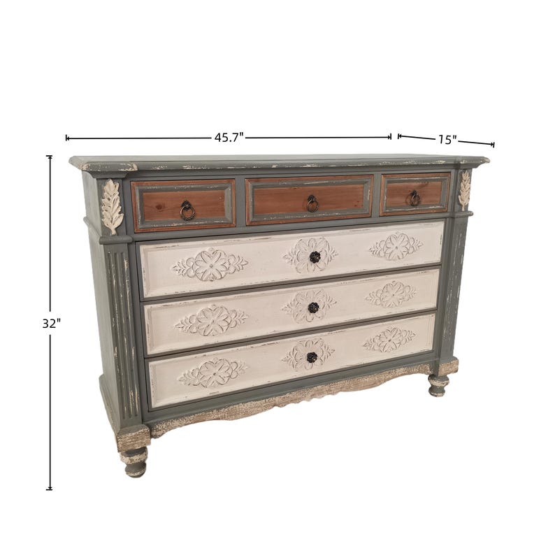 May include: A distressed-finish chest of drawers, 45.7" wide and 32" tall. The top drawers are brown, the middle drawers are white with floral carvings, and the frame is gray. The chest has decorative accents and black knobs.