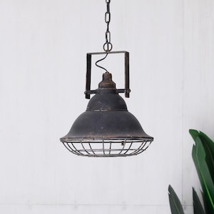 May include: A black, industrial pendant light. The light fitting has a rounded shade with a wire cage, suspended by a chain. The fixture has a distressed, vintage appearance, with visible rust and wear, giving it a rustic charm.