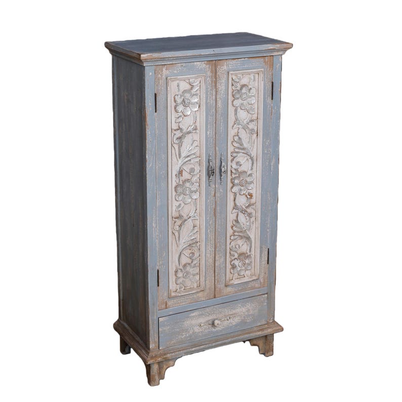 Op de afbeelding: Een verweerde, blauwgrijze houten kast met gesneden bloemendetails op de deuren. De kast heeft twee deuren, een lade en een enigszins verweerde uitstraling. De kast is ongeveer 152 cm hoog.