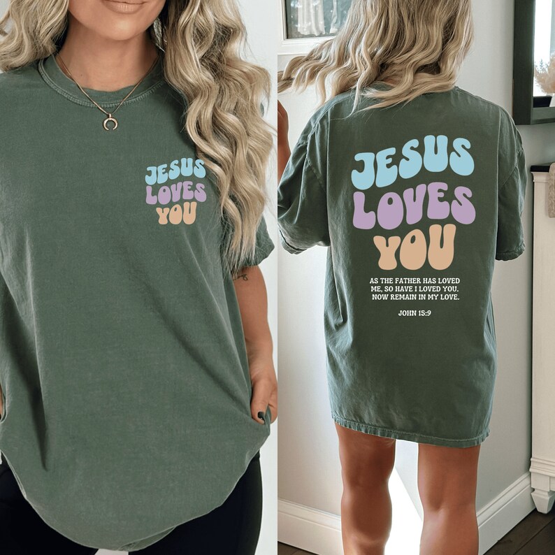 May include: A green t-shirt with the text "Jesus Loves You" in colorful bubble letters on the front and back. The back also includes the scripture John 15:9.