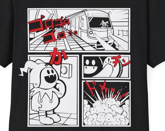 May include: Black t-shirt with a white graphic of a cartoon character in a comic book style. The graphic features a train, a character with a jester hat, and the Japanese text "カチン".