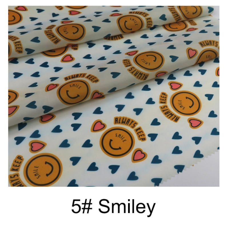 May include: White fabric with a repeating pattern of blue hearts, yellow smiley faces, and the text "ALWAYS KEEP SMILE".