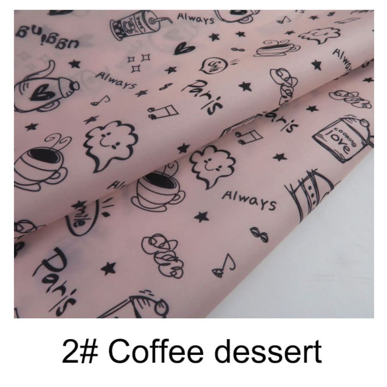 May include: Pink fabric with a black and white repeating pattern of coffee cups, stars, hearts, and the words "Paris", "Always", and "Cooking Love".