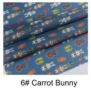 May include: Blue fabric with a repeating pattern of white bunnies holding carrots and yellow gift boxes. The text "6# Carrot Bunny" is printed at the bottom of the image.
