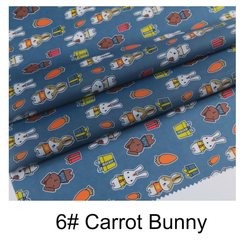 May include: Blue fabric with a repeating pattern of white bunnies holding carrots and yellow gift boxes. The text "6# Carrot Bunny" is printed at the bottom of the image.