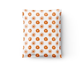 Op de afbeelding: Een witte plastic verzend envelop met een herhalend patroon van oranje en perzikkleurige bloemen.