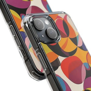 Op de afbeelding: Een transparante telefoonhoes met een kleurrijk abstract ontwerp met cirkels en geometrische vormen in tinten rood, oranje, geel, blauw en zwart. De hoes is ontworpen voor een iPhone met een camerabult.