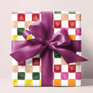 May include: A gift box wrapped in colorful checkered paper with a purple ribbon tied in a bow.
