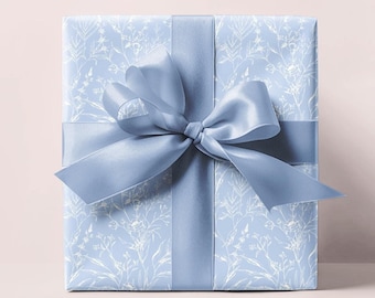 May include: A light blue gift box with a white floral pattern and a matching blue satin ribbon tied in a bow.