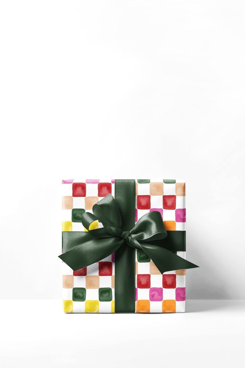 May include: A white gift box with a colorful checkered pattern and a green satin ribbon tied in a bow.