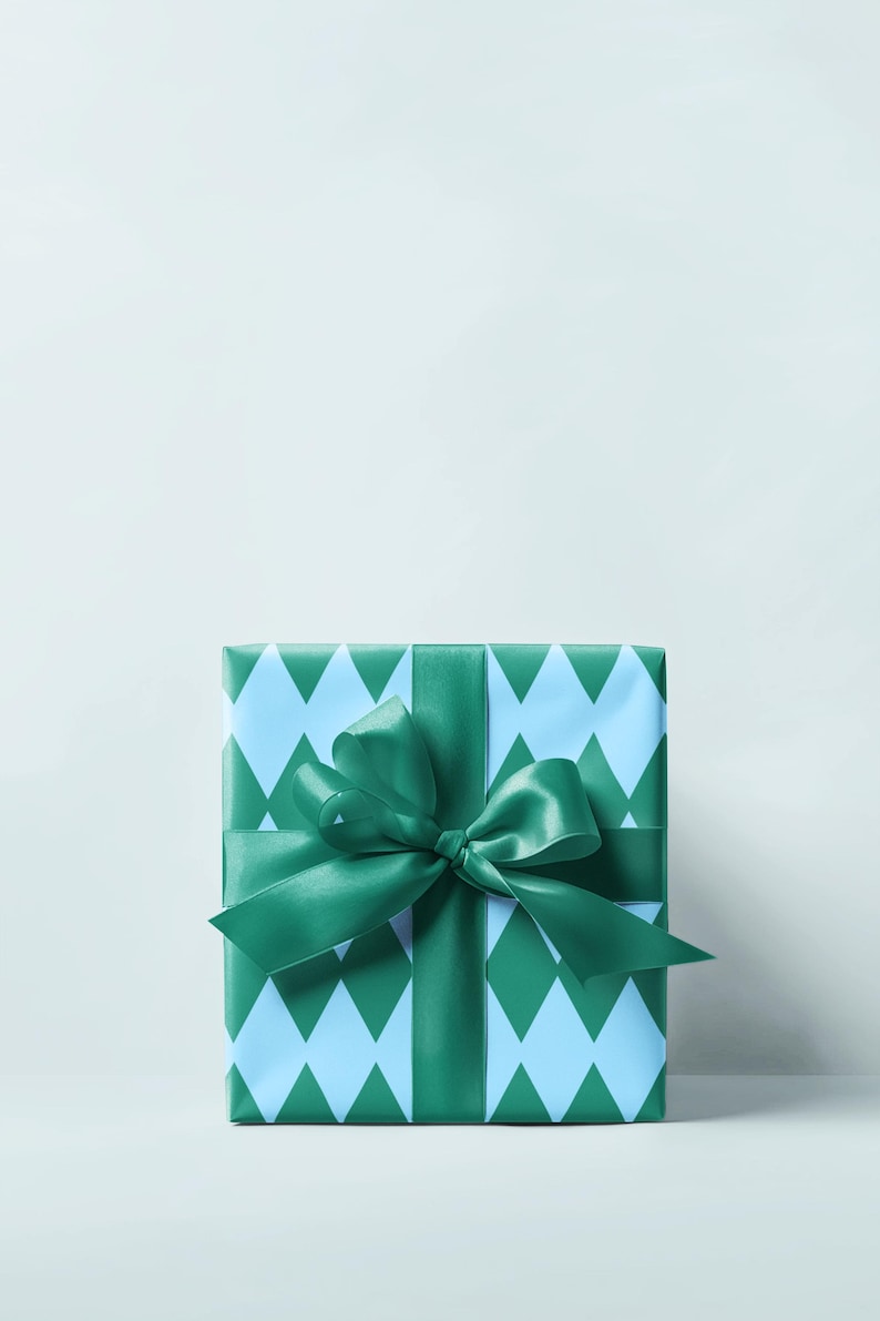 May include: A wrapped gift box with a light blue and green diamond pattern. The box is tied with a green satin ribbon and bow. The background is a solid, light blue color.