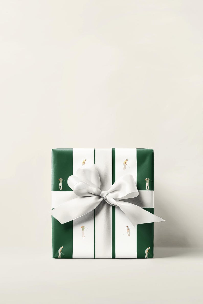 May include: A wrapped gift with green paper featuring white stripes and miniature golfers. A large white bow adorns the package. The gift is presented on a white surface.