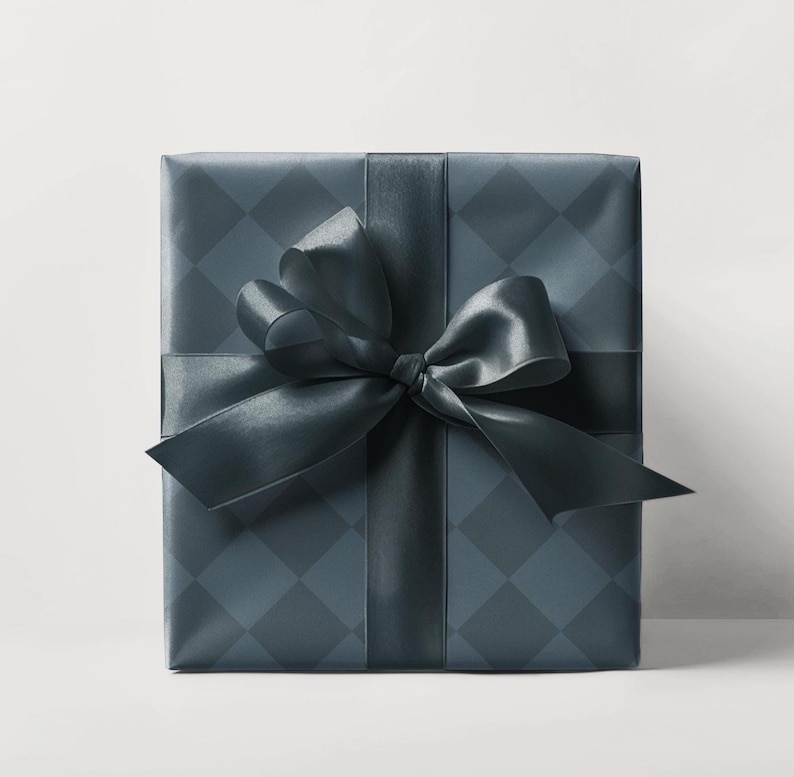 May include: A square gift box wrapped in dark teal paper with a diamond pattern. A matching satin ribbon and bow are tied around the box. The bow is centered on the top of the box.