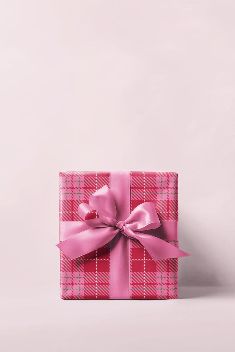 May include: A wrapped gift box with a pink plaid pattern and a matching pink satin ribbon tied in a bow. The gift box is centered on a light pink background, creating a festive and elegant presentation.