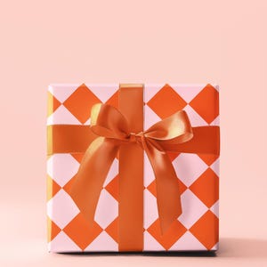 May include: A square gift box with a white and orange checkered pattern. The box is tied with a large orange satin bow.