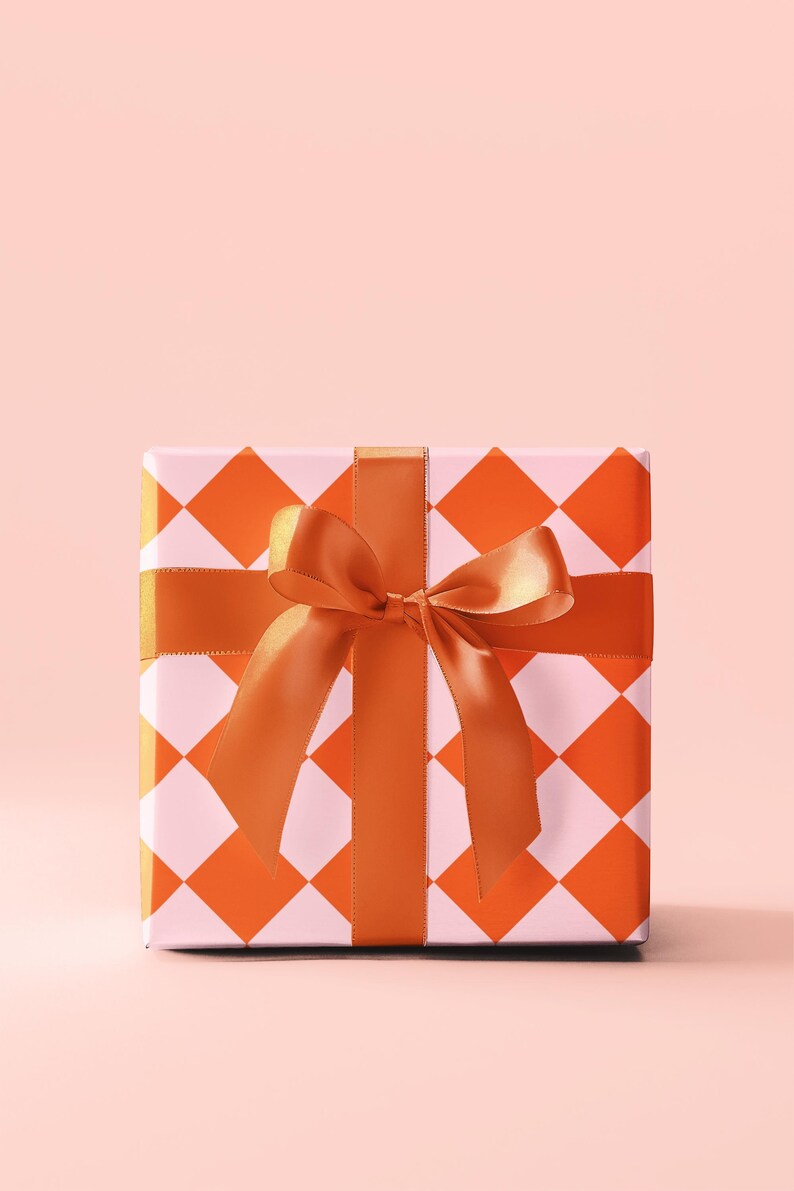 May include: A square gift box with a white and orange checkered pattern. The box is tied with a large orange satin bow.