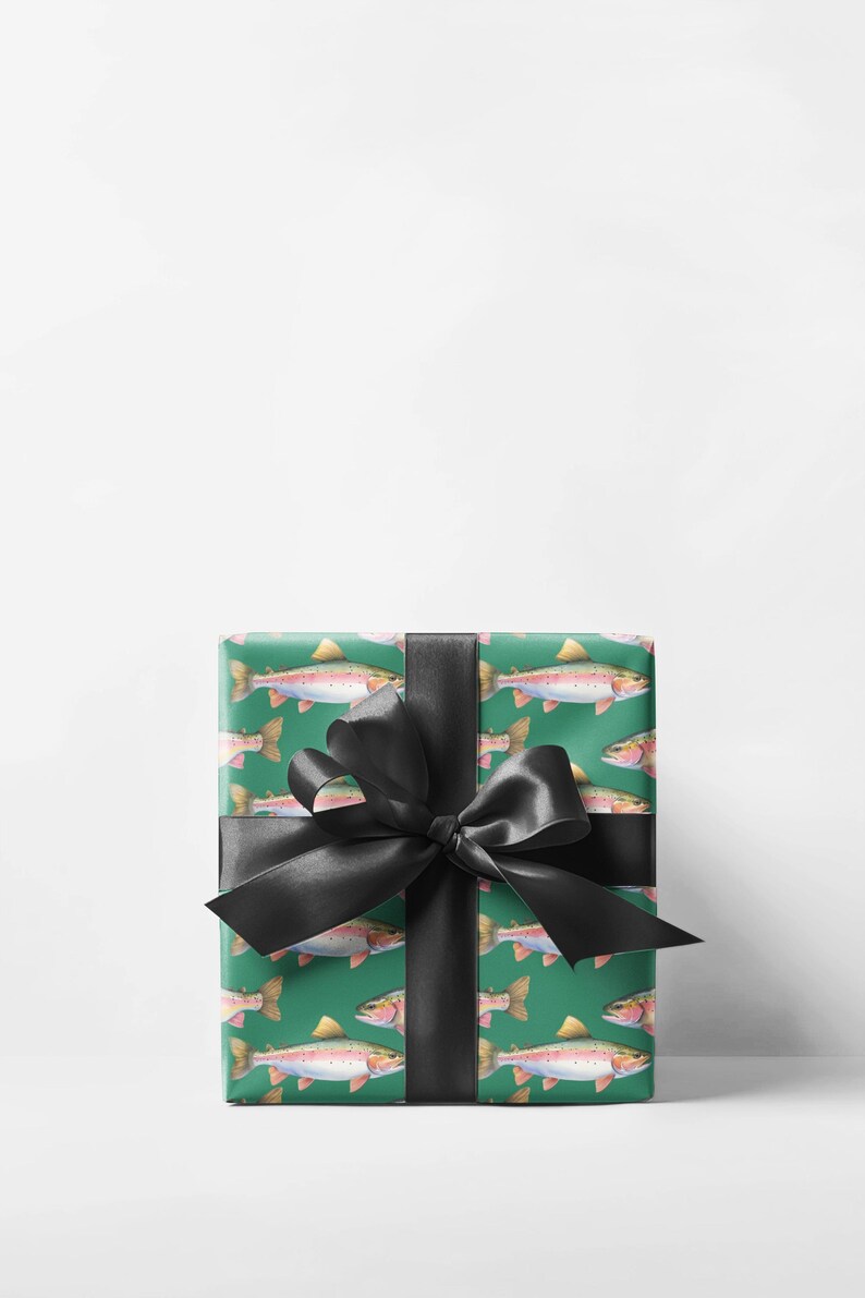May include: A wrapped gift with green wrapping paper featuring a pattern of watercolor trout. The gift is tied with a large black satin bow. The trout are depicted in shades of pink, yellow, and silver, against a green background.