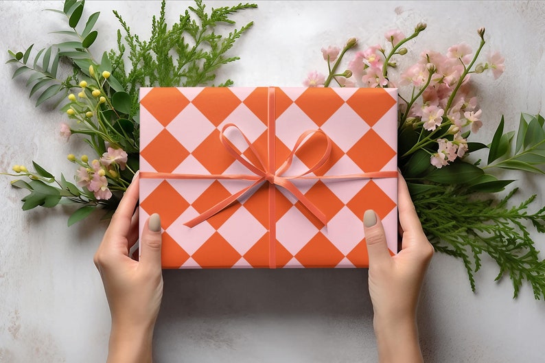 May include: A gift box wrapped in orange and pink checkered paper with a pink ribbon tied in a bow.