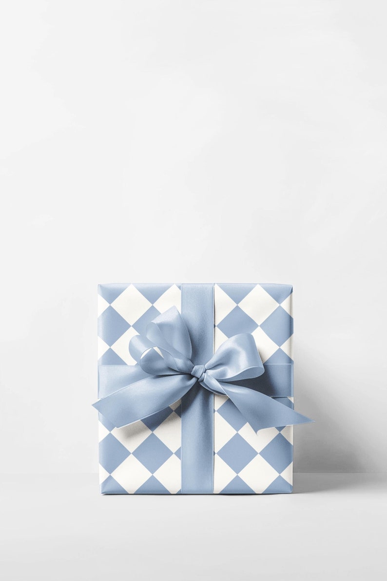 K&ouml;nnte beinhalten: Eine blaue und wei&szlig;e Schachtel mit einem blauen Satinband, das zu einer Schleife gebunden ist.
