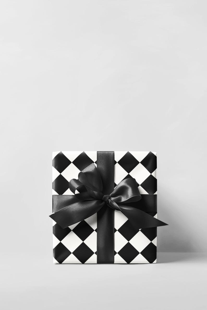 May include: A wrapped gift box with a black and white checkered pattern. The box is tied with a wide black satin ribbon and bow. The background is a solid light gray.