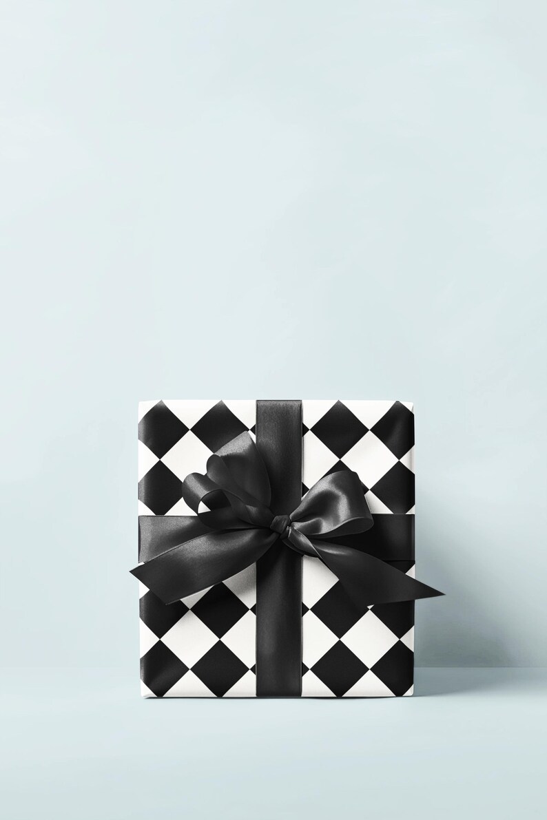 May include: A square gift box wrapped in black and white checkered paper. A wide black satin ribbon is tied around the box and forms a large bow on top. The background is a solid light blue.