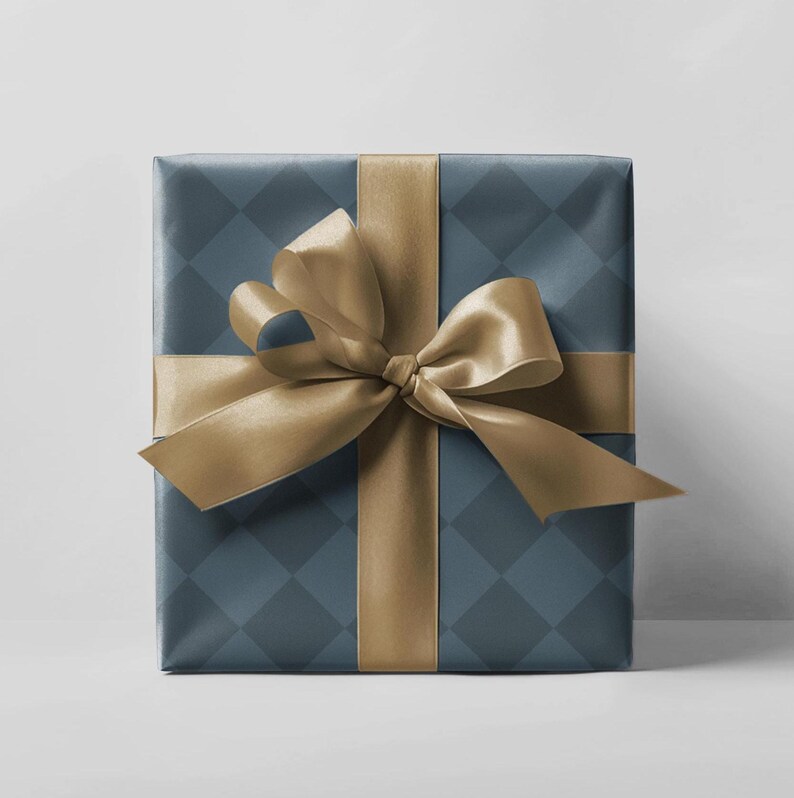 May include: A wrapped gift with a blue diamond pattern and a gold satin ribbon tied in a bow. The gift is wrapped in blue paper with a diamond pattern and a gold ribbon. The bow is centered on the top of the gift.