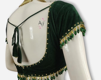 May include: A dark green velvet blouse with gold trim and green beads. The blouse has a low back with a tie closure.