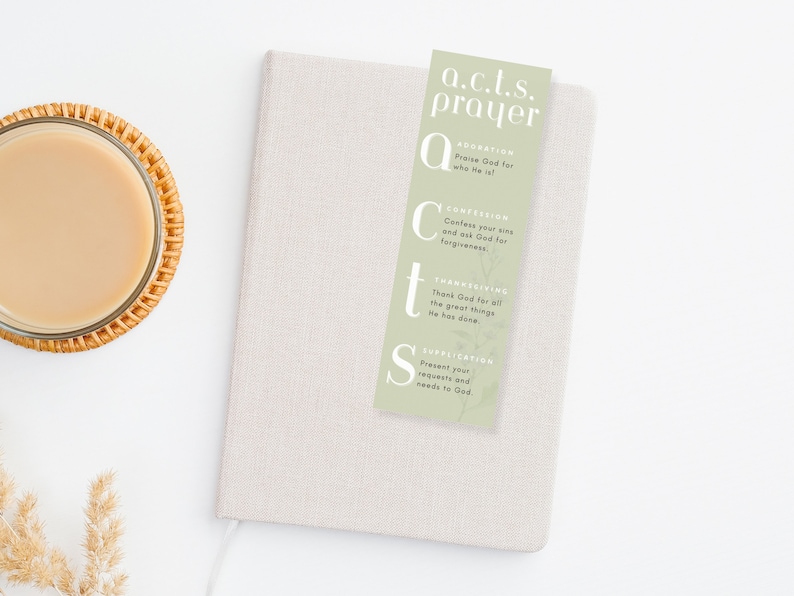 pastel green acts prayer bookmark on top of a journal