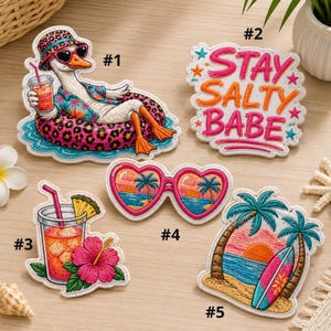Peut inclure: Collection de patchs brodés sur le thème des vacances d'été. Les motifs incluent un canard avec des lunettes de soleil, un cocktail, des lunettes de soleil en forme de cœur, une scène de coucher de soleil et la phrase "Stay Salty Babe."